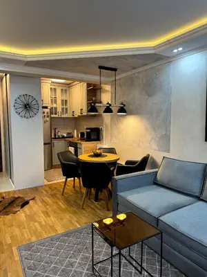 a living room with a couch and a table and a kitchen at Royal apartmani 42 in Vrnjci