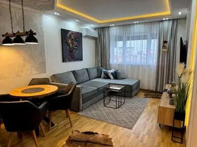 a living room with a couch and a table at Royal apartmani 42 in Vrnjci