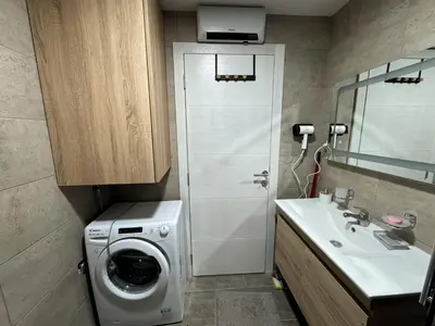 a bathroom with a washing machine and a sink at Royal apartmani 42 in Vrnjci