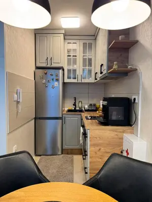 a kitchen with a stainless steel refrigerator and a table at Royal apartmani 42 in Vrnjci
