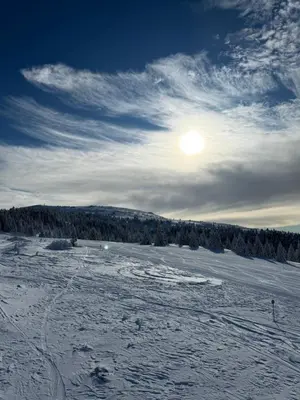 a snow covered field with the sun in the sky at Rajski Kutak Kopaonik in Kopaonik