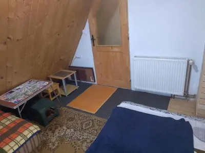 a room with a bed and a table and a door at KOPANIKSkiRooms in Kopaonik
