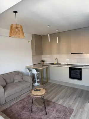 a kitchen and living room with a couch and a table at Apartman Vera in Trnava