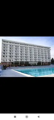 a large building with a swimming pool in front of it at Apartman Vera in Trnava