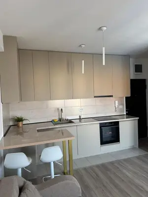 a kitchen with white cabinets and a table and chairs at Apartman Vera in Trnava