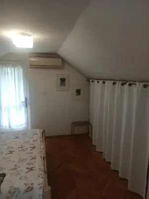 a bedroom with white curtains and a bed and a window at Apartmani Jelena 6 in Vrnjačka Banja