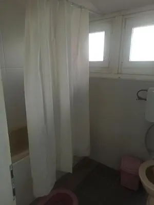 a bathroom with a white shower curtain and a toilet at Apartmani Jelena 6 in Vrnjačka Banja