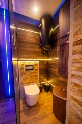 a bathroom with a toilet in a room with wooden walls at Ryo Golden Imperial 2 in Kruševac