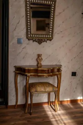 a table with a chair and a mirror on a wall at Ryo Golden Imperial 2 in Kruševac