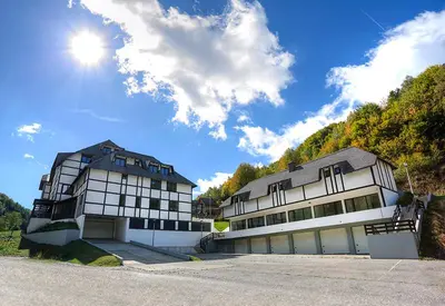 a large building with the sun in the sky at Zimski san in Brzeće
