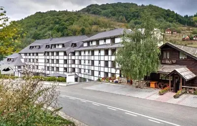 a large hotel with a building on the side of a road at Zimski san in Brzeće