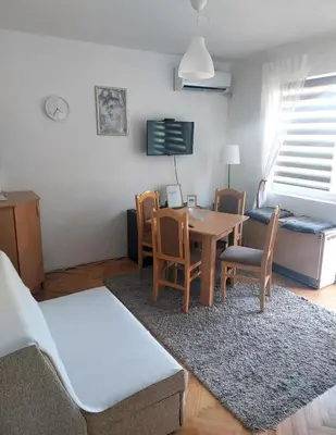 a living room with a table and chairs and a couch at Apartman Javor in Vrnjačka Banja