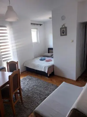 a small room with a bed and a table at Apartman Javor in Vrnjačka Banja