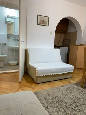 a bed in a room with a bathroom at Apartman Javor in Vrnjačka Banja