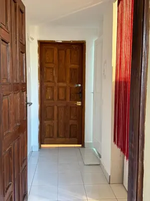 a hallway with a wooden door and a tile floor at Airport, Belgrade, 1 bedroom, 1 living room in Bukorovac