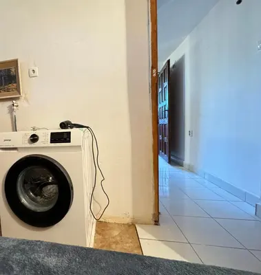 a washing machine in a room with a blue light at Airport, Belgrade, 1 bedroom, 1 living room in Bukorovac