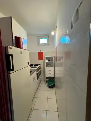 a white kitchen with a refrigerator and a stove at Airport, Belgrade, 1 bedroom, 1 living room in Bukorovac