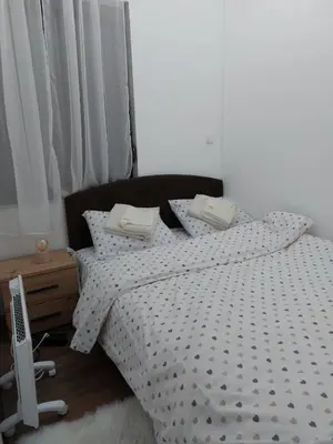 a bedroom with a bed with a black and white comforter at Apartman Ivana Kopaonik in Kopaonik