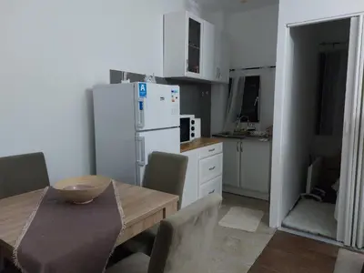 a kitchen with a table and a white refrigerator at Apartman Ivana Kopaonik in Kopaonik
