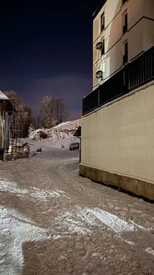 a snow covered street next to a building at Apartman Ivana Kopaonik in Kopaonik