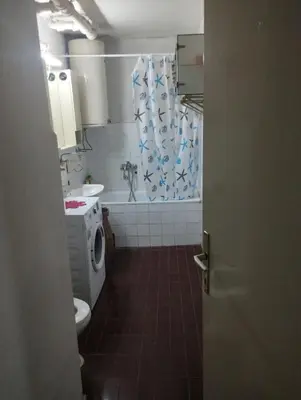 a bathroom with a toilet and a shower curtain at Apartman Suva reka in Leskovac