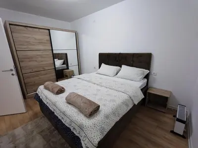 a bedroom with a large bed and a mirror at Stan na dan Bor in Bor