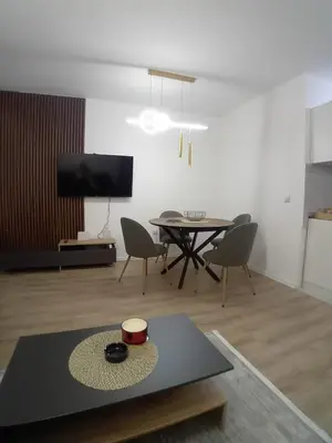 a living room with a table and chairs and a tv at Stan na dan Bor in Bor