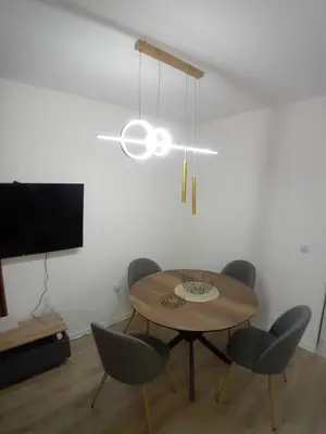 a dining room with a table and chairs and a television at Stan na dan Bor in Bor