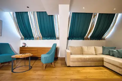 a living room with a couch and blue chairs at Hotel Nais Nis Autoput in Niš