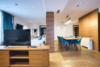 a living room with a television and a dining room at Hotel Nais Nis Autoput in Niš