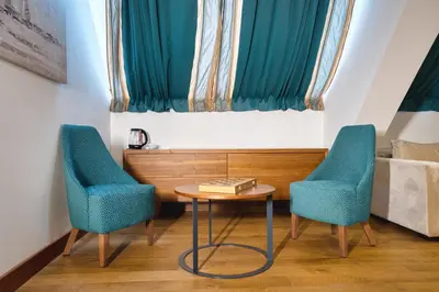 two chairs and a table in a room with a window at Hotel Nais Nis Autoput in Niš