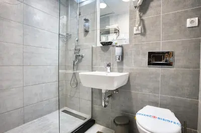 a bathroom with a toilet and a sink and a shower at Hotel Nais Nis Autoput in Niš