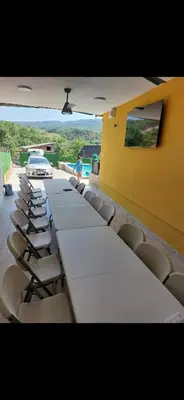 a long table and chairs in a room with a car at Bazen Jelasnica 1 in Niš