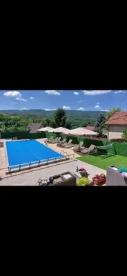 a large blue swimming pool with umbrellas in a yard at Bazen Jelasnica 1 in Niš
