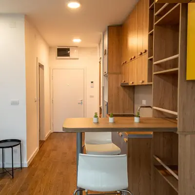 a kitchen with wooden cabinets and a wooden table at Delta residence in Niš