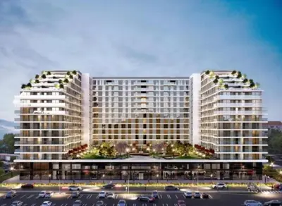 two tall white buildings in a parking lot at Delta residence in Niš