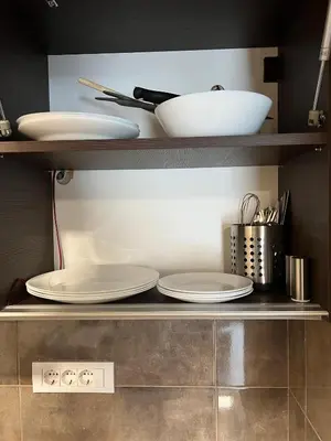 a shelf with plates and utensils in a kitchen at Apartment in Belvedere Hills Luxury Apartments and Spa in Kopaonik