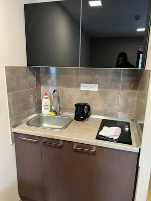a kitchen counter with a sink and a person in the mirror at Apartment in Belvedere Hills Luxury Apartments and Spa in Kopaonik