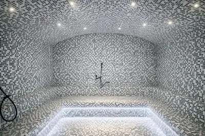 a bathroom with a bath tub in a room with tiled walls at Apartman Monte - Ressidence Hill, Kopaonik in Kopaonik