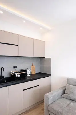 a kitchen with white cabinets and a couch in a room at Apartman Monte - Ressidence Hill, Kopaonik in Kopaonik