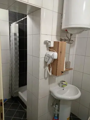 a bathroom with a sink and a toilet and a shower at LIN Apartman in Vladičin Han