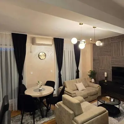 a living room with a couch and a table at Apartman IVA LUX Vrnjacka Banja in Vrnjci