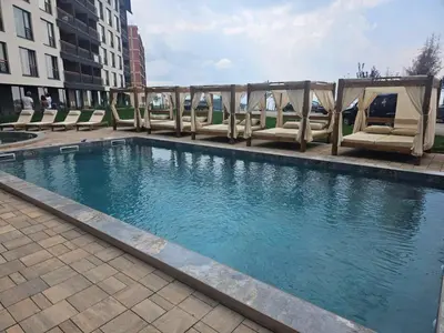 a swimming pool with lounge chairs in a building at Sierra Apartments Residence Hill & SPA Centar in Kopaonik
