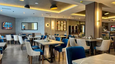 a restaurant with tables and chairs in a restaurant at Sierra Apartments Residence Hill & SPA Centar in Kopaonik