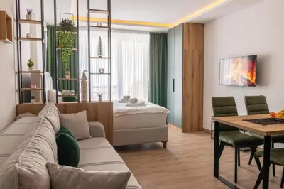 a living room with a couch and a dining room at Sierra Apartments Residence Hill & SPA Centar in Kopaonik