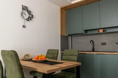 a kitchen with a table with a bowl of oranges on it at Sierra Apartments Residence Hill & SPA Centar in Kopaonik