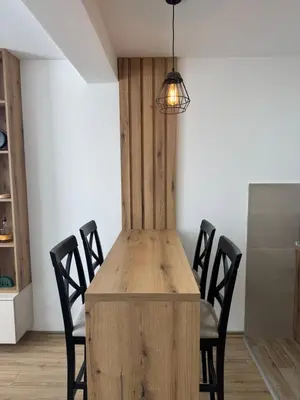a dining room with a wooden table and chairs at Apartman Pogled Contra in Kopaonik
