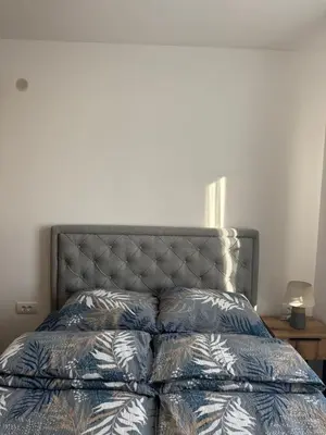 a bedroom with a bed with a blue comforter at Apartman Pogled Contra in Kopaonik