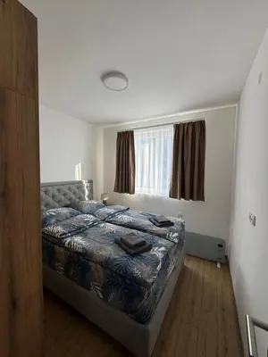 a bedroom with a bed in front of a window at Apartman Pogled Contra in Kopaonik