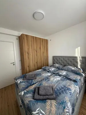 a bedroom with a bed with a blue comforter at Apartman Pogled Contra in Kopaonik